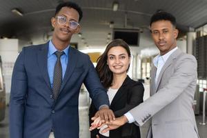 grupo de empresários em pé com as mãos juntas. sucesso e conceito vencedor - equipe de negócios feliz comemorando a vitória no escritório. close-up de empresários juntando as mãos. foto