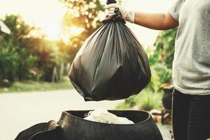 mão de mulher segurando o saco de lixo para reciclagem de limpeza foto