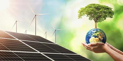mão segurando a árvore crescendo no globo com célula solar e turbina. conceito de energia limpa para salvar o mundo. elementos desta imagem mobilada nasa