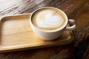café com leite quente em uma mesa de madeira foto