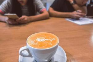 café com leite quente em uma mesa de madeira. foto