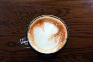 café com leite quente em uma mesa de madeira foto