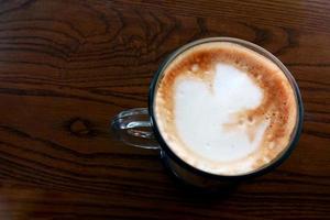 café com leite quente em uma mesa de madeira foto