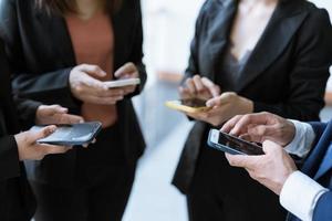 grupo de jovens empresários em pé e usando smartphone juntos comunicação de conceitos. foto