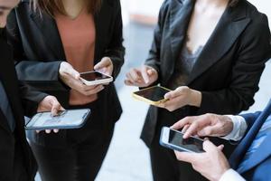 grupo de jovens empresários em pé e usando smartphone juntos comunicação de conceitos. foto