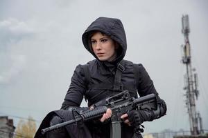 jovem mulher no estilo techwear preto moderno com rifle posando no telhado, retrato de mulher ruiva cyperpunk ou conceito pós-apocalíptico