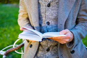 jovem hipster masculino ler livro no parque outono foto