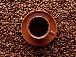 xícara marrom de café expresso no fundo de grãos de café espalhados, vista superior, close-up, macro