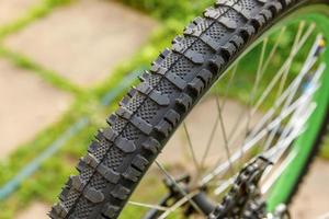 moto esperando mecânico para reparo na oficina de bicicletas, ao ar livre. roda de bicicleta perto pronta para exames, corrige o sistema de transmissão de ciclo moderno. manutenção de bicicletas, conceito de loja de esportes. foto