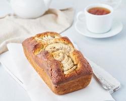 pão de banana integral, bolo com banana. o café da manhã em fundo cinza claro foto