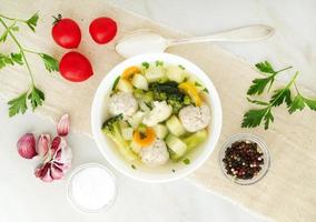 tigela de sopa, uma xícara de caldo e legumes, almôndegas feitas de peru e frango, vista superior, banner de largura longa