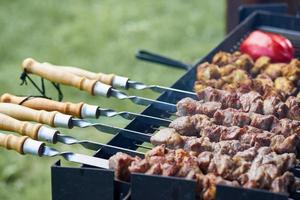 churrasco shashlik kebab com winglets e tomates em chargrill semi-acabados no espeto foto