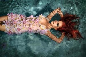 retrato de menina ruiva bonita na água foto