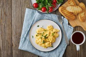 ovos mexidos, omelete, vista superior, copie o espaço. café da manhã com ovos fritos, xícara de chá, tomate na velha mesa de madeira