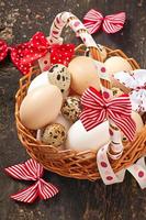 ovos de páscoa e cesta em um fundo de madeira foto