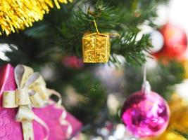 decorações de árvores verdes de natal decoradas têm caixa de presente ouro bola vermelha pendurada pinho, folhas em turva de fundo foto