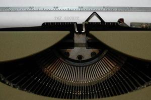 velha máquina de escrever vintage retrô. uma folha branca com o texto impresso top secret. foto