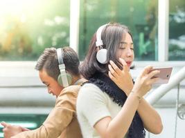 menino e menina jogam e ouvem música em seus telefones celulares foto