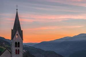 villanders, tirol do sul, itália, 2016 campanário da igreja paroquial ao nascer do sol foto