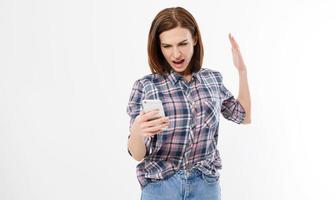 jovem frustrada chocada com telefone. fêmea com raiva no celular. retrato de uma mulher morena com raiva gritando no celular. emoção humana, reação, expressão. foto