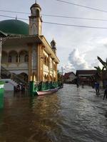 Kasongan, Indonésia, 5 de maio de 2022 mesquita inundada e uma canoa foto