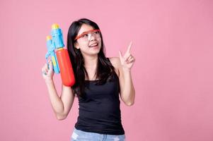 belas mulheres asiáticas seguram pistolas de água de plástico em um templo antigo durante songkran, o festival de água mais bonito e divertido da tailândia foto