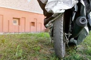 motocicleta sob capa protetora na rua foto