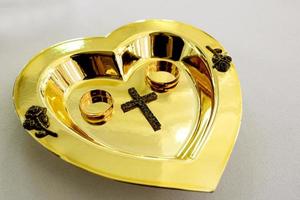 anéis de casamento em uma placa de ouro na igreja