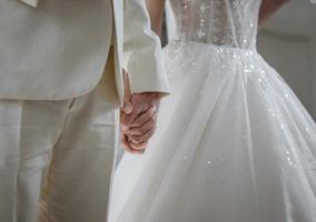 detalhes delicados da festa de casamento. recém-casados de mãos dadas. foto