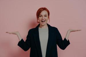 jovem mulher caucasiana ruiva animada feliz sorrindo enquanto compara dois produtos foto