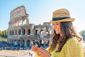 mulher verificando fotos perto do Coliseu, em Roma, Itália