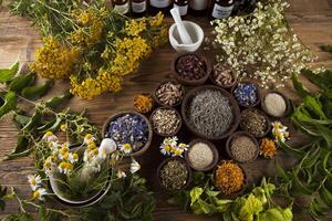 medicina alternativa, ervas secas e argamassa no fundo da mesa de madeira foto