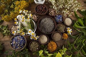 medicina alternativa, ervas secas e argamassa no fundo da mesa de madeira foto