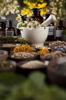 medicina alternativa, ervas secas e argamassa no fundo da mesa de madeira