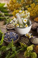 medicina alternativa, ervas secas e argamassa no fundo da mesa de madeira foto