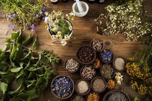 medicina natural, ervas, argamassa no fundo da mesa de madeira foto