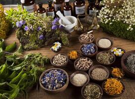 medicina alternativa, ervas secas e argamassa no fundo da mesa de madeira foto