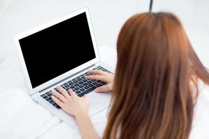 closeup jovem asiática usando laptop para lazer no quarto, garota trabalhando online com notebook freelance, conceito de negócio, vista superior. foto
