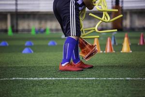 bola infantil está coletando táticas no campo de grama com barreira para treinamento de habilidade foto