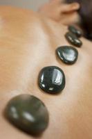 mulher relaxante no spa com massagem com pedras quentes
