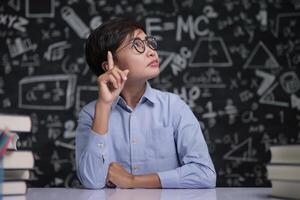 o professor sentou-se pensando em ensinar na sala de aula foto