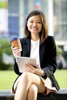 executivo de negócios asiáticos feminino jovem usando tablet