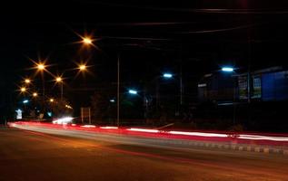 faróis de carros e lâmpadas de rua noturnas. foto