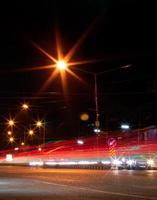 faróis de carros e lâmpadas de rua noturnas. foto