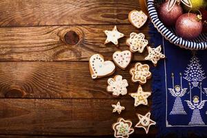quadro de biscoitos doces de natal em fundo de madeira marrom escuro. vista superior e copie o espaço. brincar. feliz ano novo conceito foto