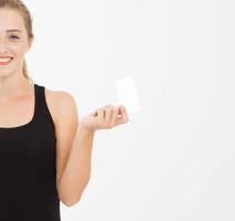 garota caucasiana, mulher de camiseta segura cartão de visita isolado no fundo branco foto