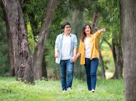 casais femininos asiáticos lgbt andando e relaxando no jardim e se abraçando com amor e felicidade foto