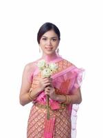 uma mulher tailandesa encantadora em vestido tailandês antigo segurando uma flor de lótus que é usada para adorar monges religiosos foto