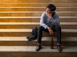 empresário sentado no parque ao ar livre e estressado por causa do fracasso no trabalho de negócios foto