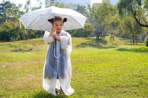 uma garotinha estava feliz em um guarda-chuva contra a chuva foto